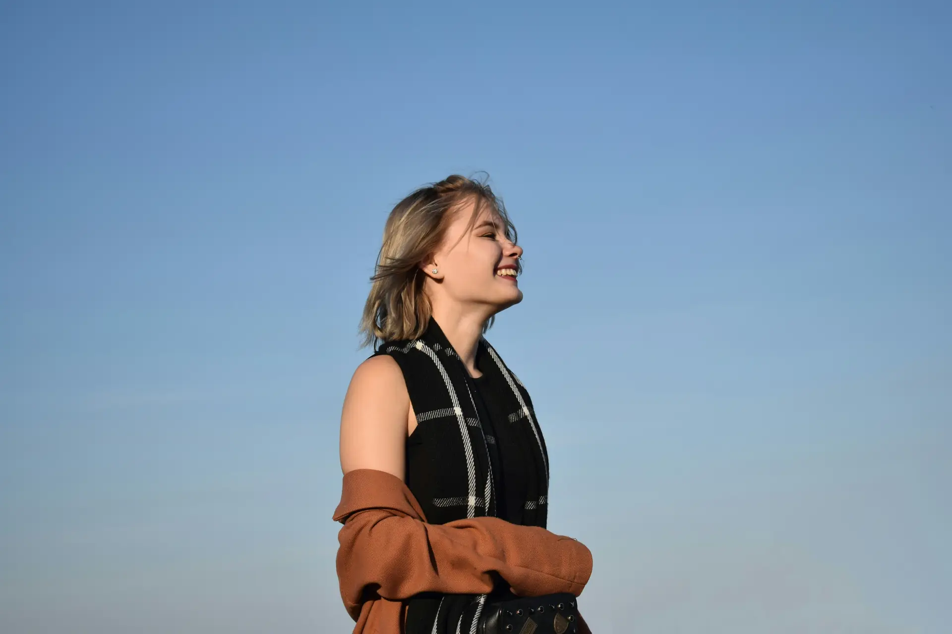 Persona sonriendo al cielo despejado